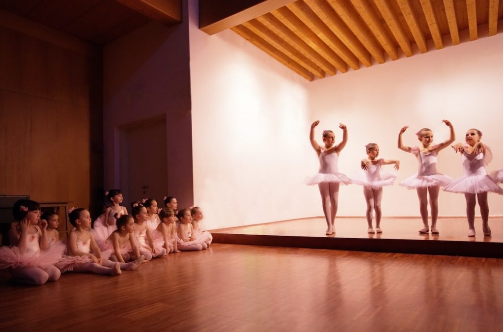 young ballerinas in pink tutus dancing on a stage