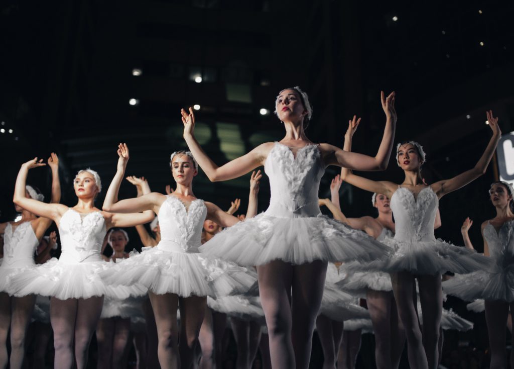 group of ballerinas performing onstage in white tutus