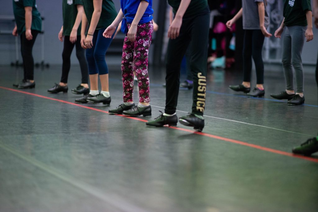 children standing in a line with tap dance shoes on