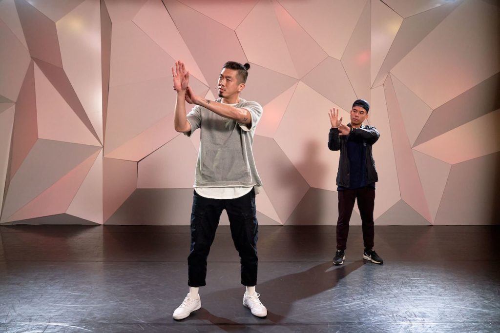 Anthony Lee and Kinjaz looking at their hands at cli studios.