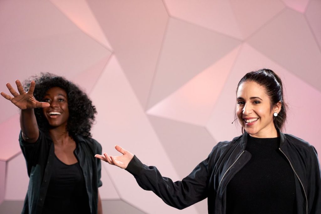 Gabrielle Ruiz standing with female dancer holding hand out as to present the dancer at cli studios. 
