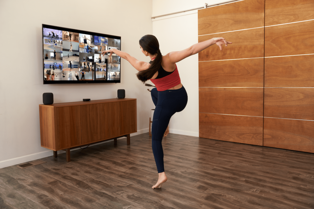 young female dancer taking a dance class via zoom in her living room 