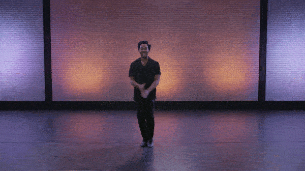 jazz hands being performed by dancer infront of a brick wall.