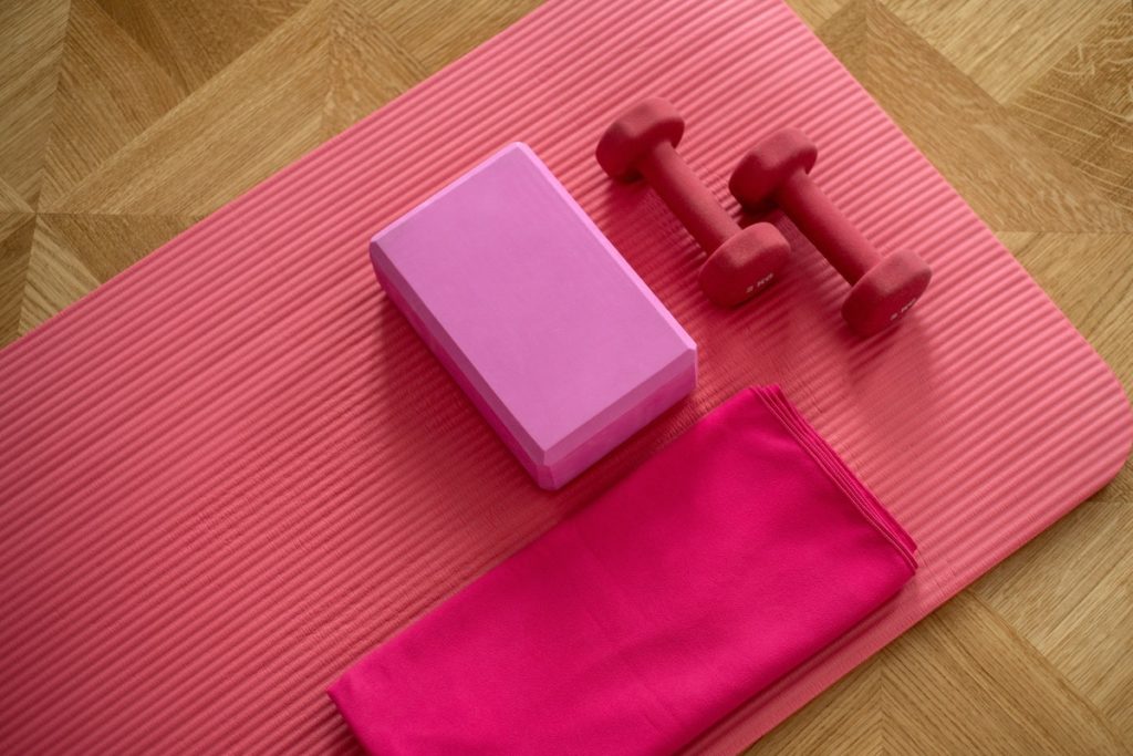 pink weights and yoga block on top of a pink yoga mat