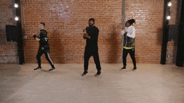 twitch performing the reebok in front of brick wall.