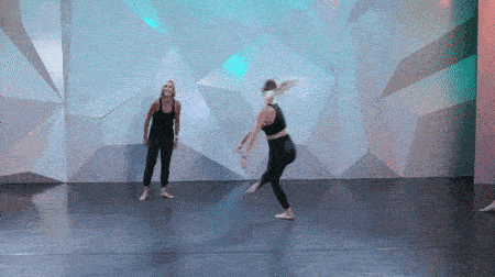Krista miller standing behind student performing a stag leap at cli studios.
