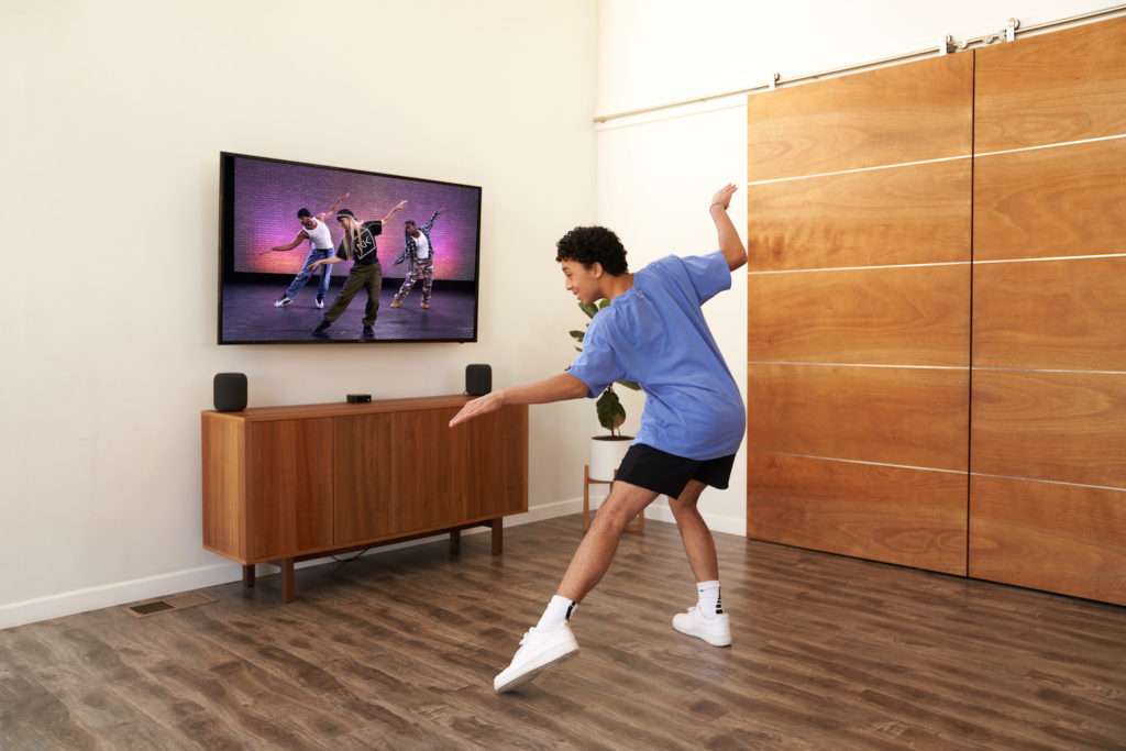 Person dancing in front of TV in their home