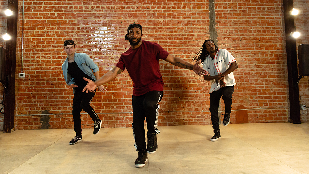 Twitch and two other dancers in front of brick wall