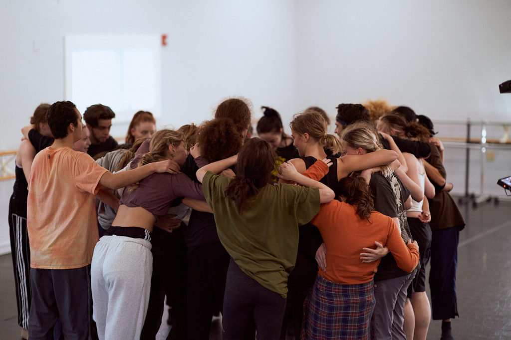 group of CLI Conservatory dancers in a huddle with teddy forance