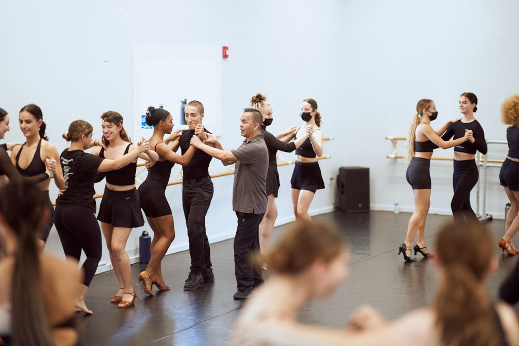 CLI Conservatory dancers wearing heels and black dance outfits in a dance studio dancing in pairs