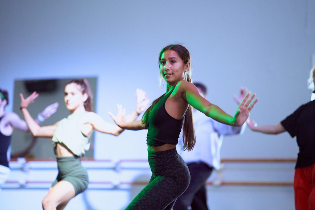 Girl dancer posing with arms outstretched in a dance studio