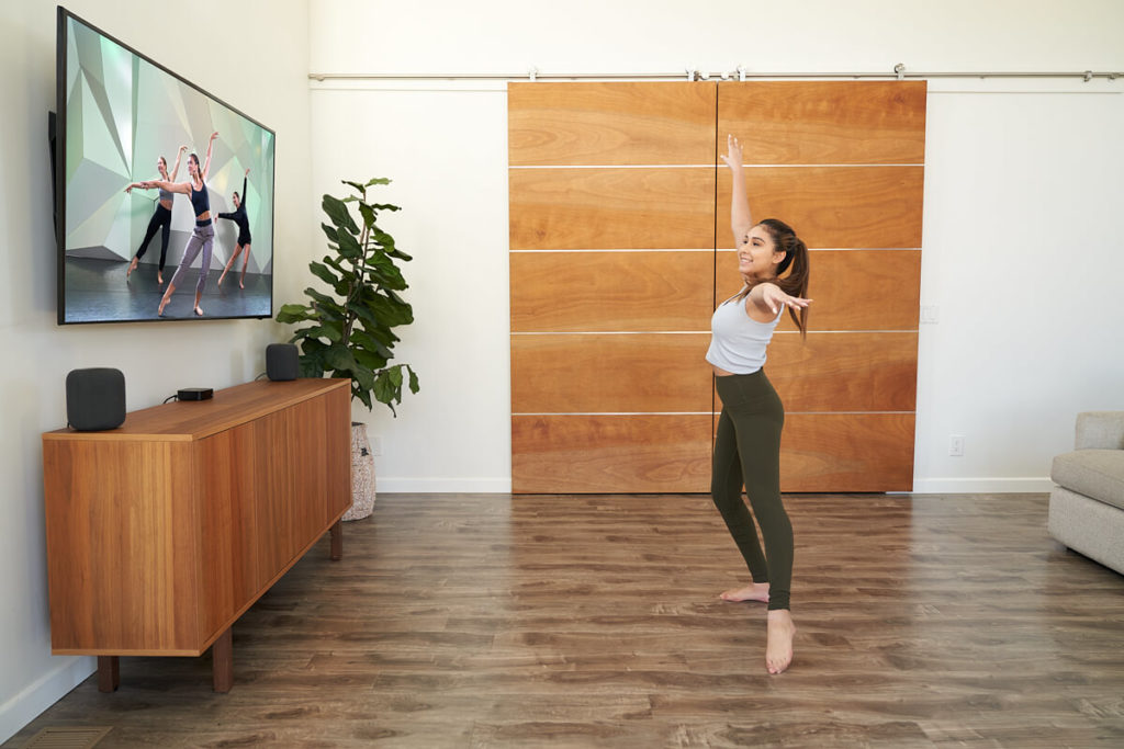Dancer dancing at home in front of the television in their living room