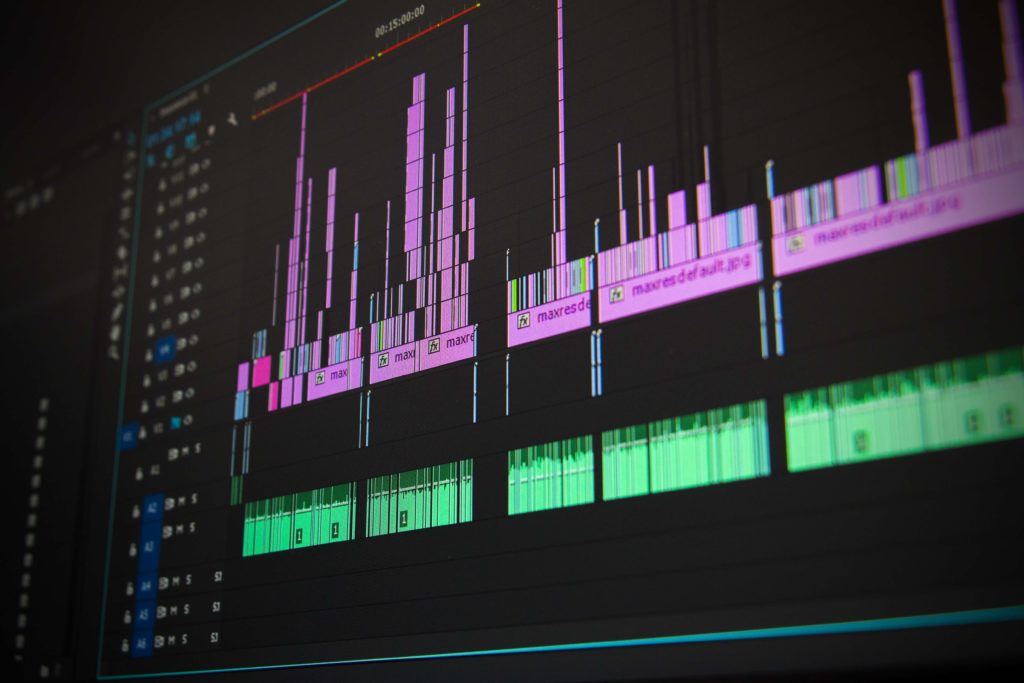 picture of computer screen showing digital music editor with varying pink and green bars. 