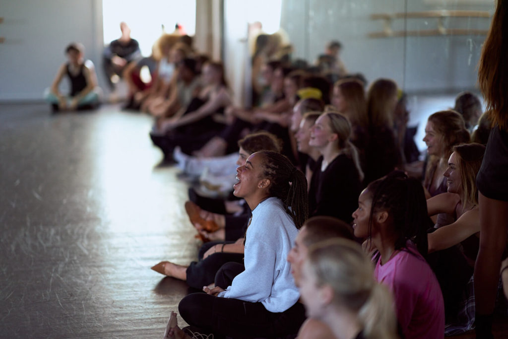 CLI Conservatory dancers sitting in front of the mirror in a dance studio smiling watching dance