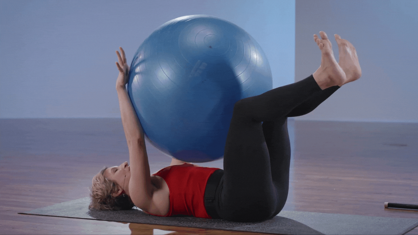 Katie Schaar demonstrating core roll exercise with exercise ball inbetween arms and knees rolling to the right